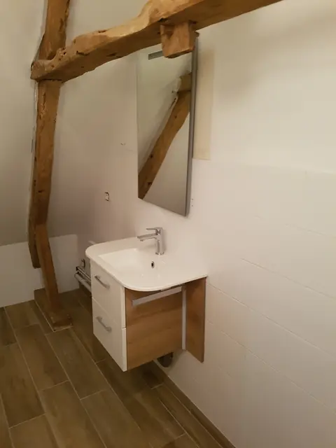 Salle d’eau avec vasque suspendue et sol imitation bois